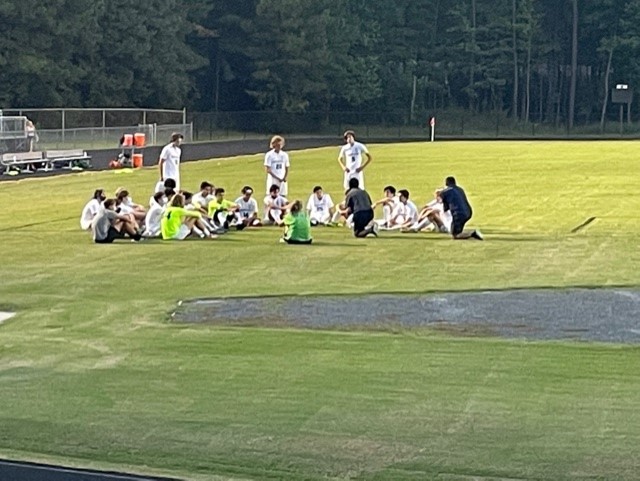 The Gators get tactics from Coach Solakoglu, as they wait to take on the second half.