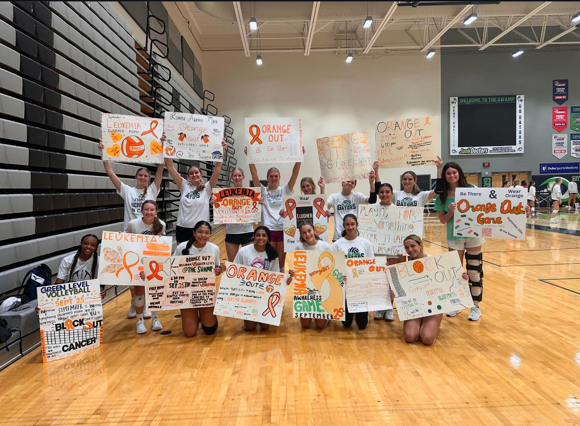 Varsity women’s Green Level Volleyball team crafting posters in honor of the Orange Out Dedication game. These posters will be littered throughout the school in order to raise awareness for the pending match. 
