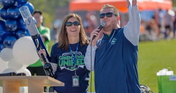 Mrs. Summers Wields the T-Shirt Cannon alongside Mr. Connett at The Special Olympics Opening Ceremony.